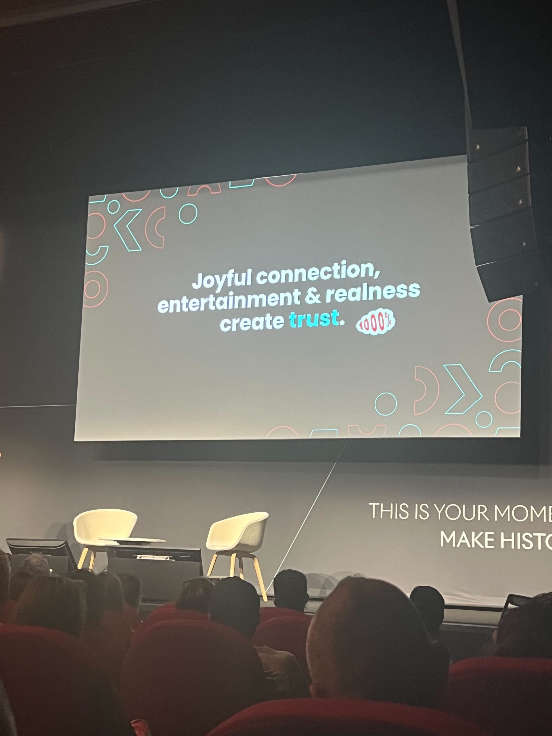 Presentation at Cannes showing a slide that reads "joyful connection, entertainment & realness create trust."