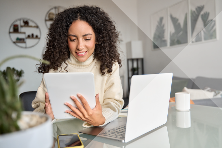 Woman sitting at a counter on laptop and tablet